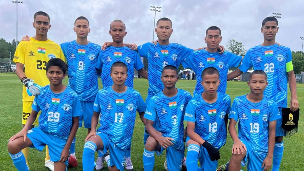 The Minerva Academy U15 football team posing in their blue match kits with the Indian flag during the MIC Cup 2026.